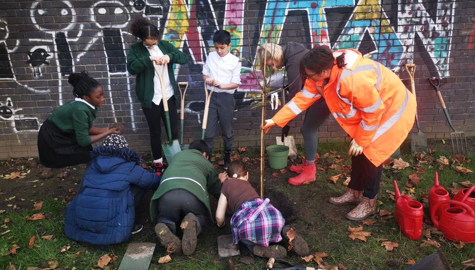 Pupils, tree and Veolia staff member 