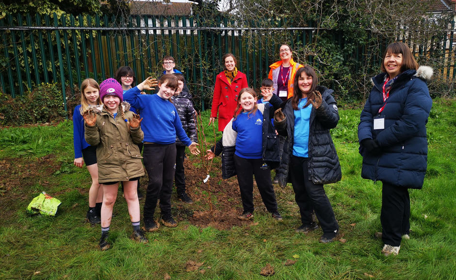 The images shows a group of students, a Veolia Officer and Cllr Meg Davidson around one of the fruit trees planted as part of the campaign